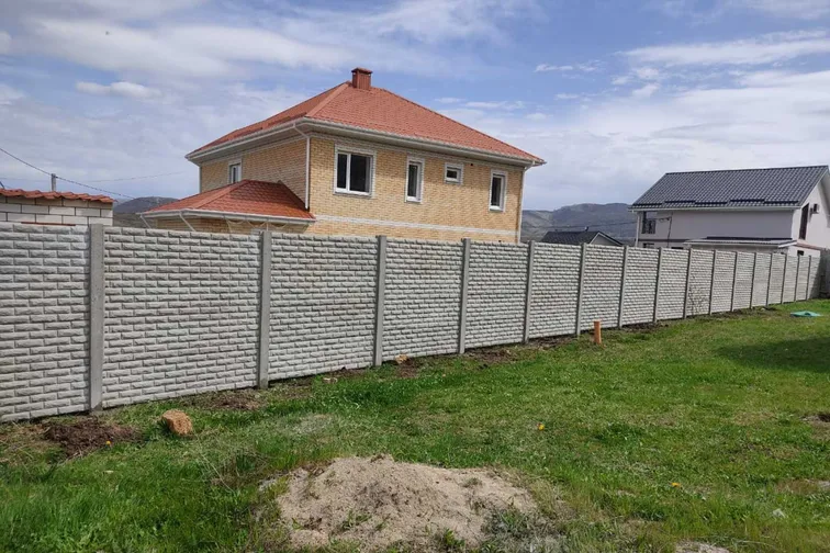 Еврозабор по периметру участка с кирпичным домом под красной крышей