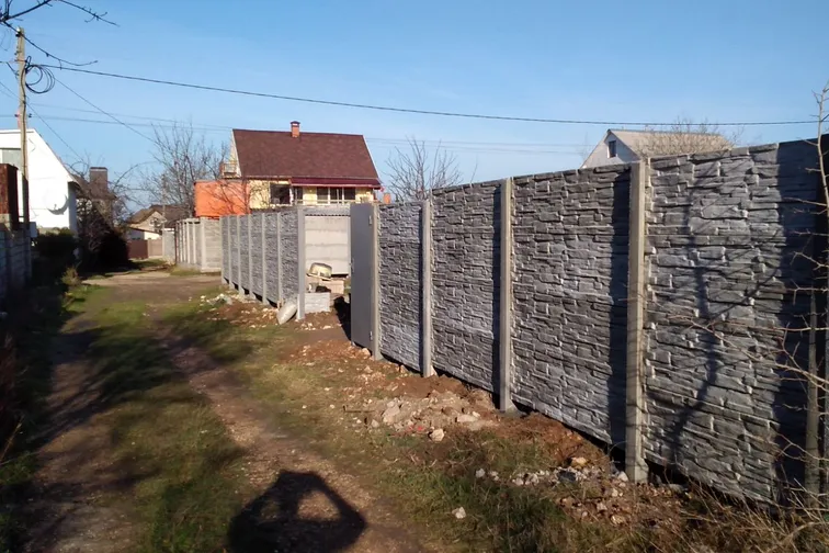 Еврозабор вдоль сельской улицы с фактурой под камень